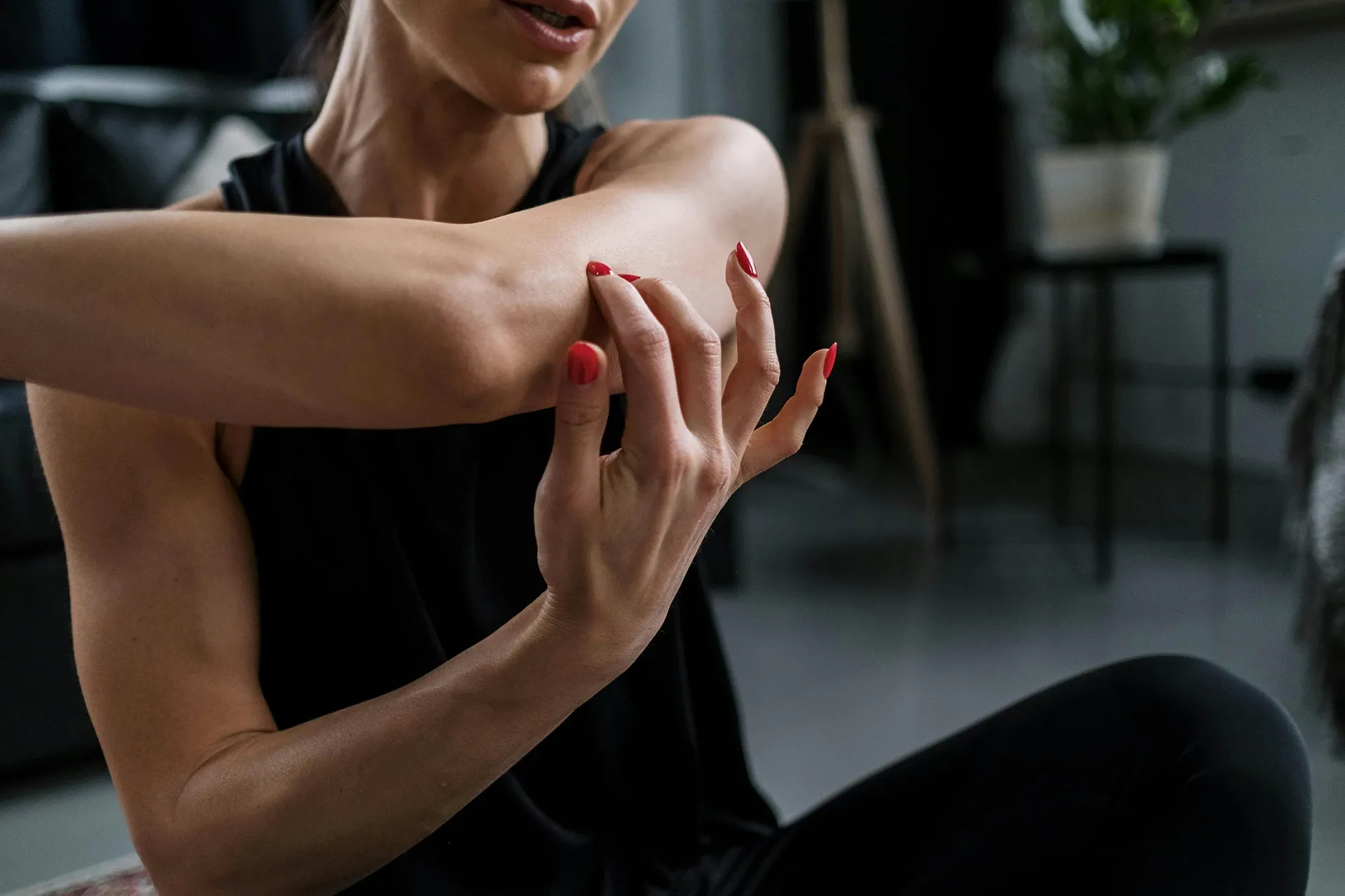 woman holding arm and showing elbow pain