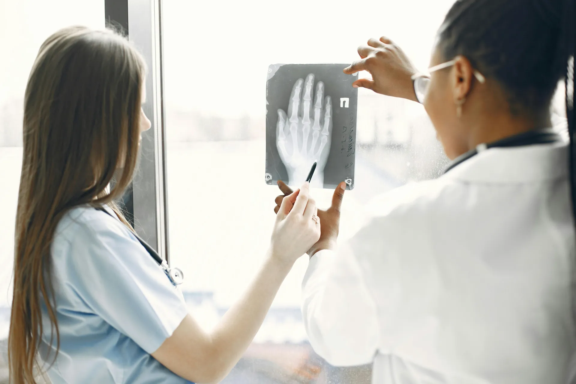 medical staff looking at x-ray of hand