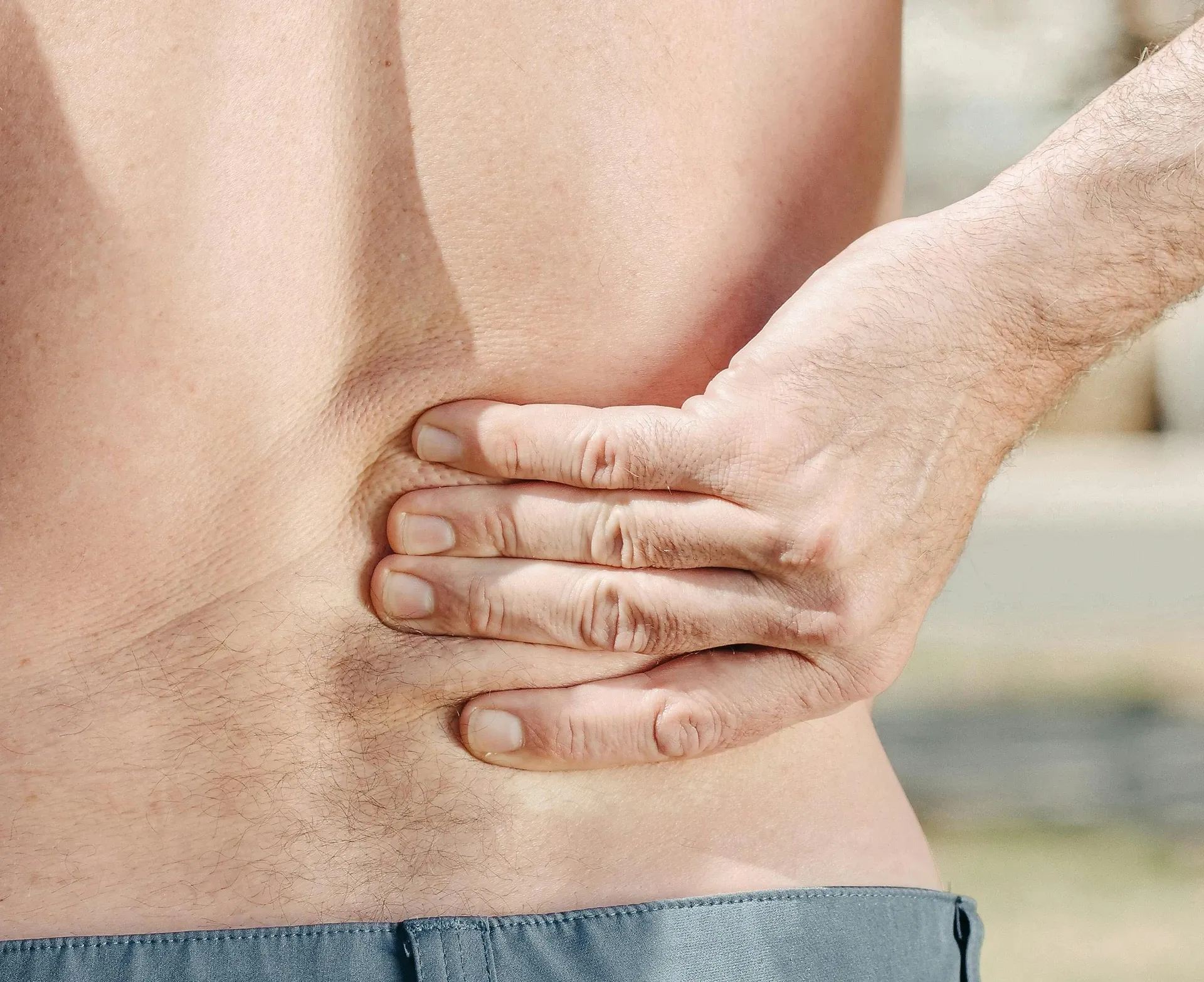 person holding lower back in pain