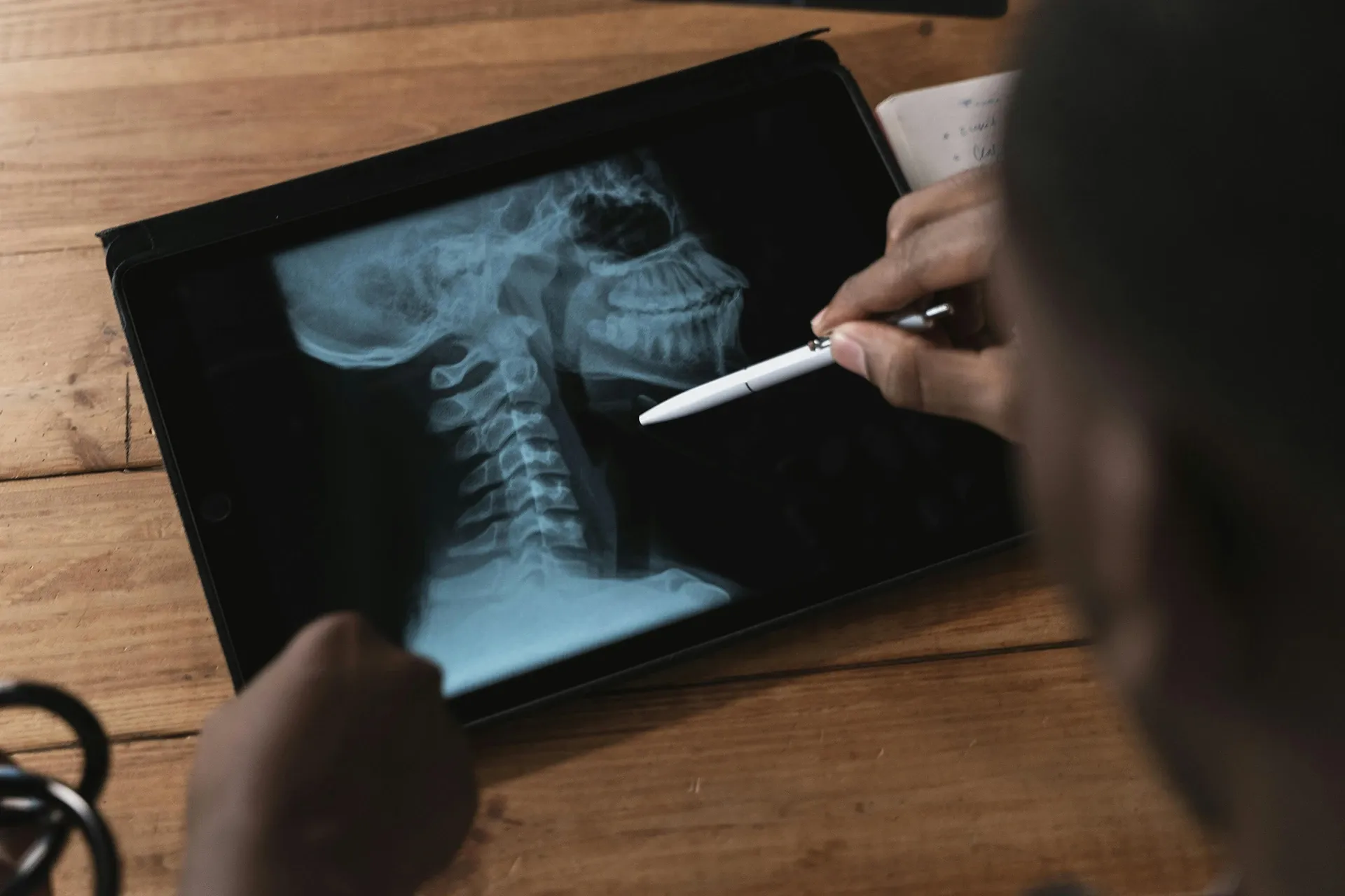 physician looking at neck x-ray on tablet
